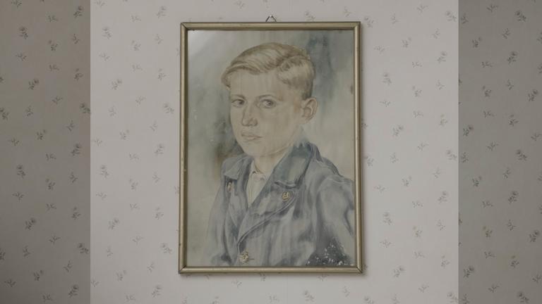 Ein Gemälde von einem Jungen, das an der Wand hängt.