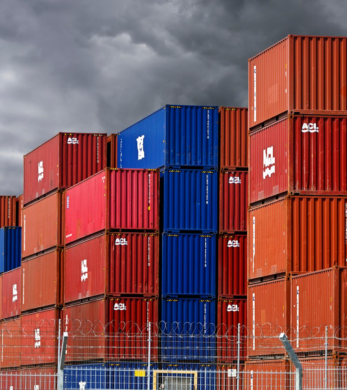 Dunkle Wolken über gestapelten Containern im Hamburger Hafen