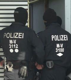 Zwei maskierte Polizisten von hinten.