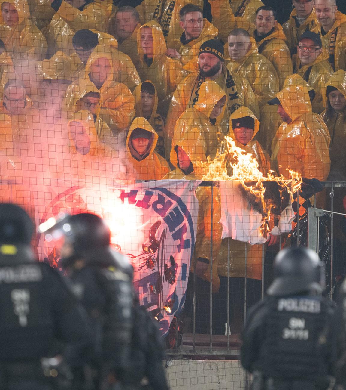 Polizisten stehen während einer Spielunterbrechung im Stadion vor dem K-Block mit Dresdner Fans am 04.04.2026 in Dresden.