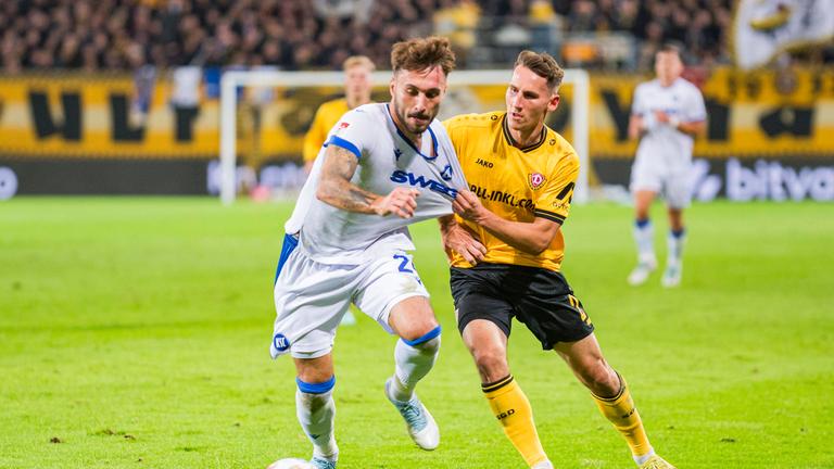 Fabian Schleusener (Karlsruher SC) und Konrad Faber (Dynamo Dresden) kämpfen.