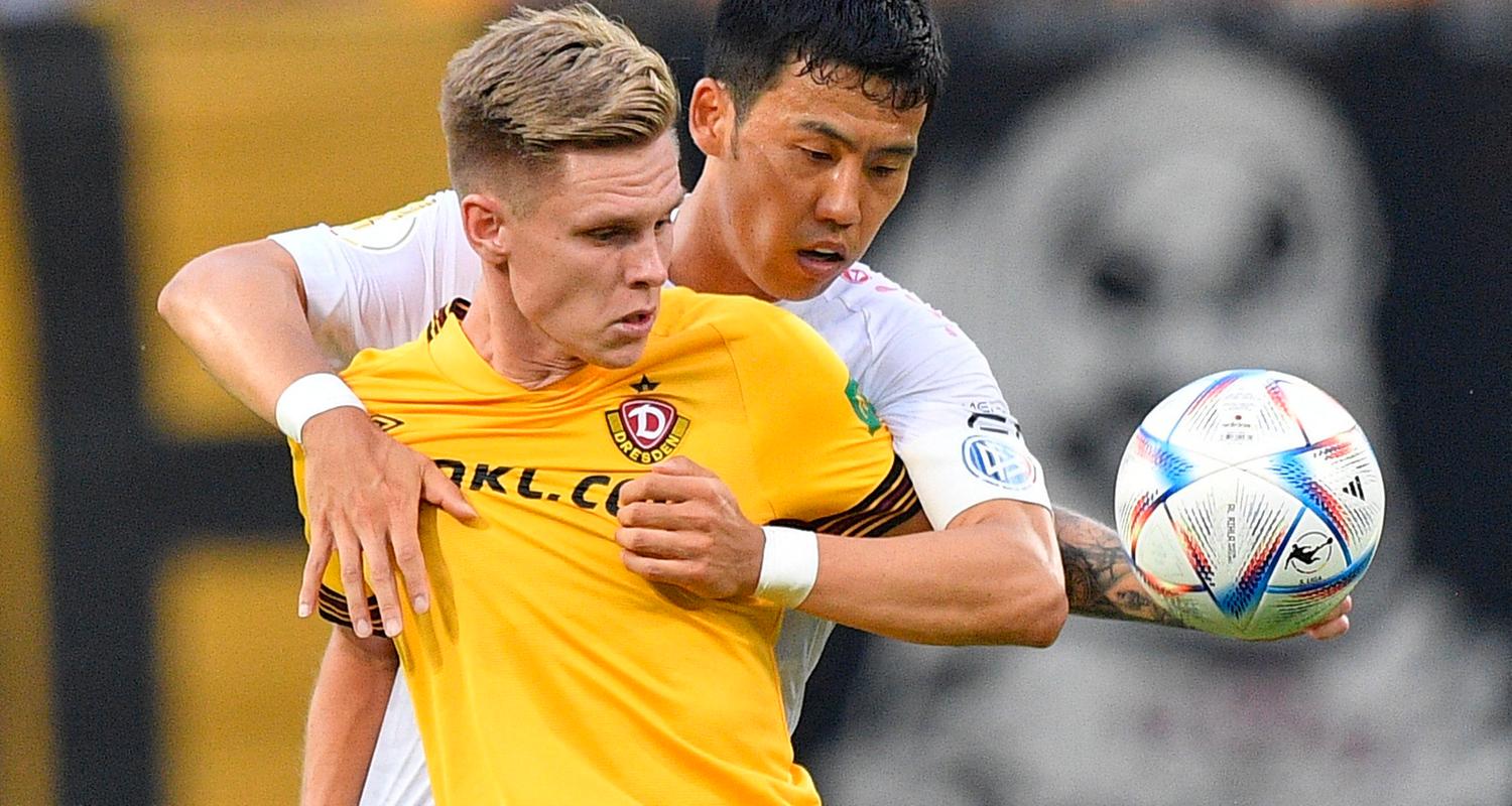 Wataru Endo vom VfB Stuttgart umklammert den Dresdner Julius Kade