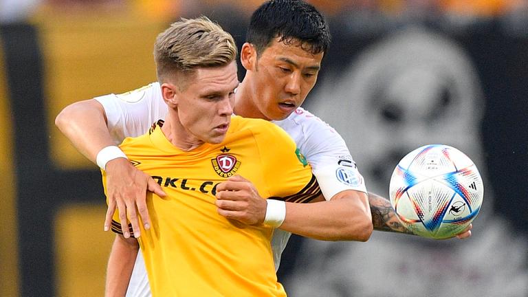 Wataru Endo vom VfB Stuttgart umklammert den Dresdner Julius Kade