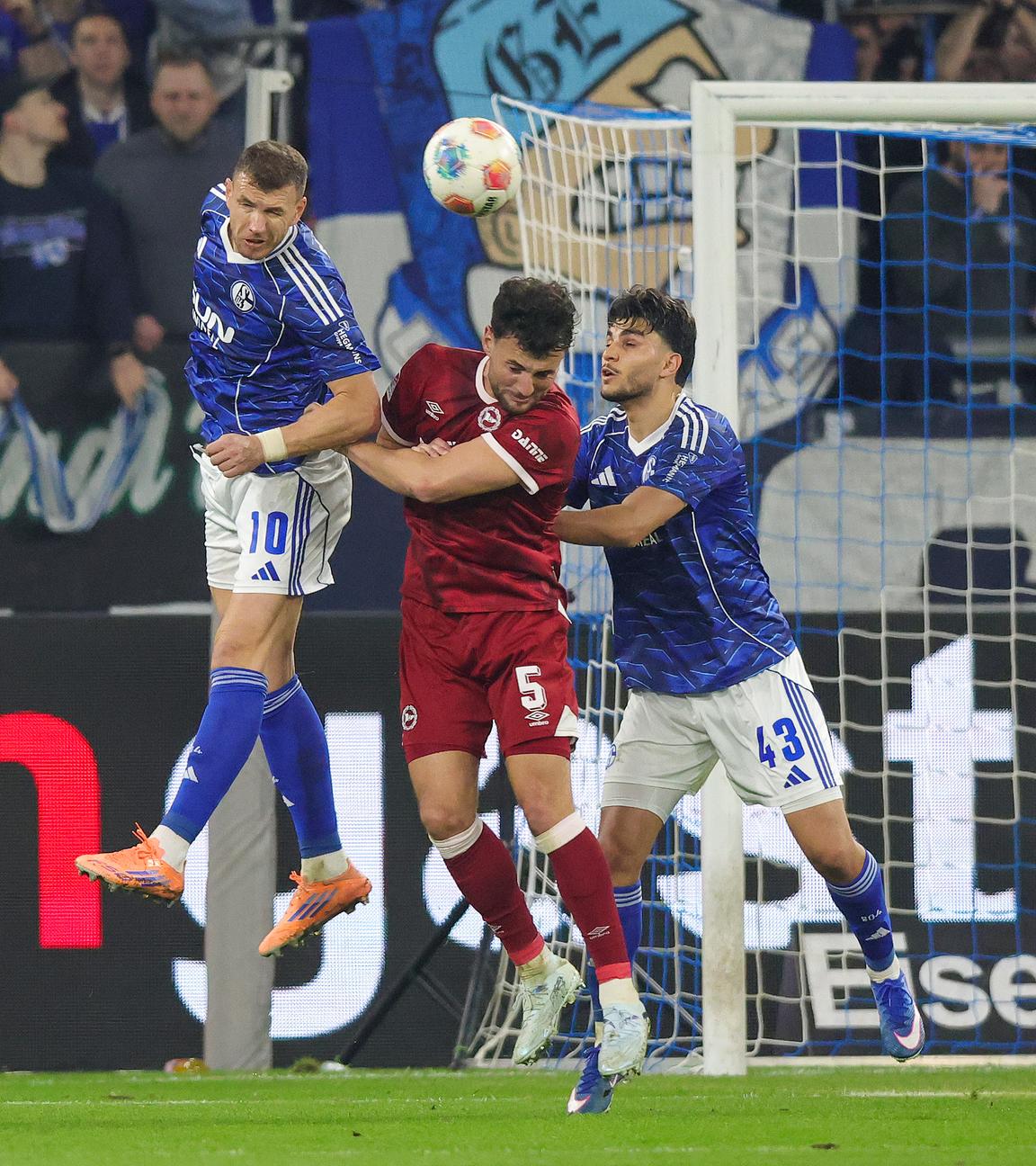 Schalkes Mittelstürmer Edien Dzeko kann sich im Kopfballduell mit Bielefelds Abwehrspieler Maximilian Bauer durchsetzen