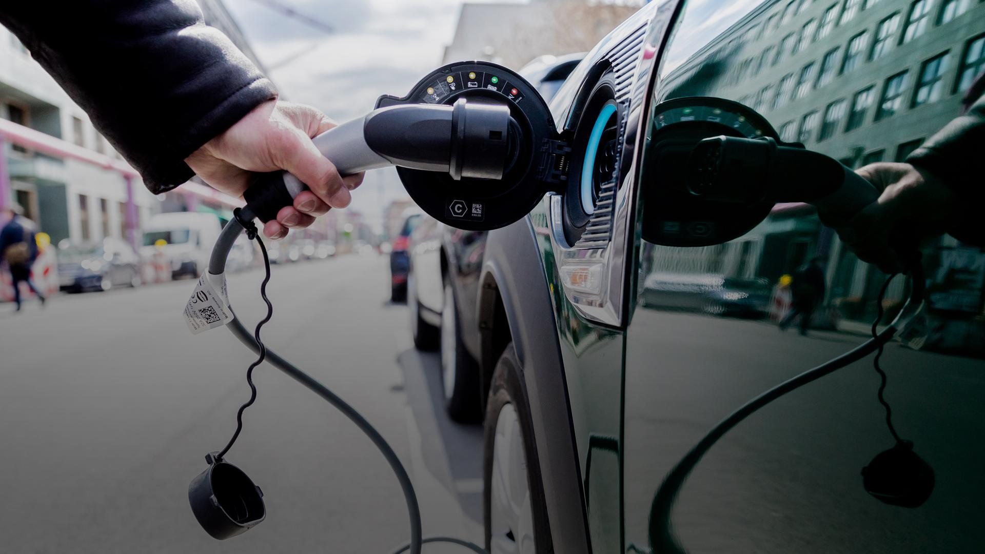 Archiv Ein Mann entfernt an einem Auto mit Plug-in-Hybrid-Antrieb in Berlin-Mitte am 16.04.2021 den Stecker. 