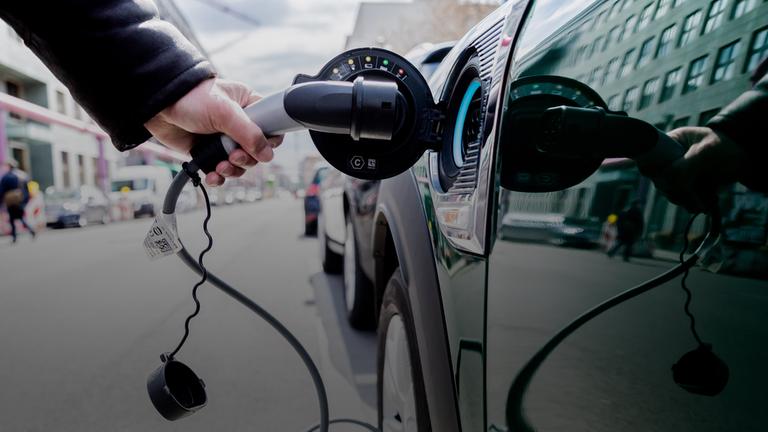 Archiv Ein Mann entfernt an einem Auto mit Plug-in-Hybrid-Antrieb in Berlin-Mitte am 16.04.2021 den Stecker. 