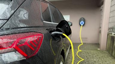 Symbolbild: Ein E-Auto wird an einer Wallbox aufgeladen