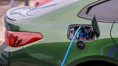 Ein Elektrofahrzeug von BMW lädt an einer Ladesäule