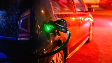 Ein Elektroauto lädt an einer öffentlichen Schnellladesäule
