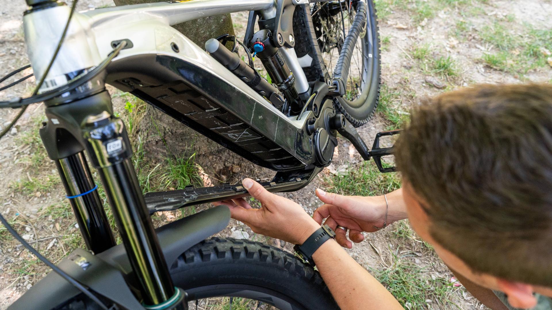 Mann tauscht Akku am E-Bike aus.