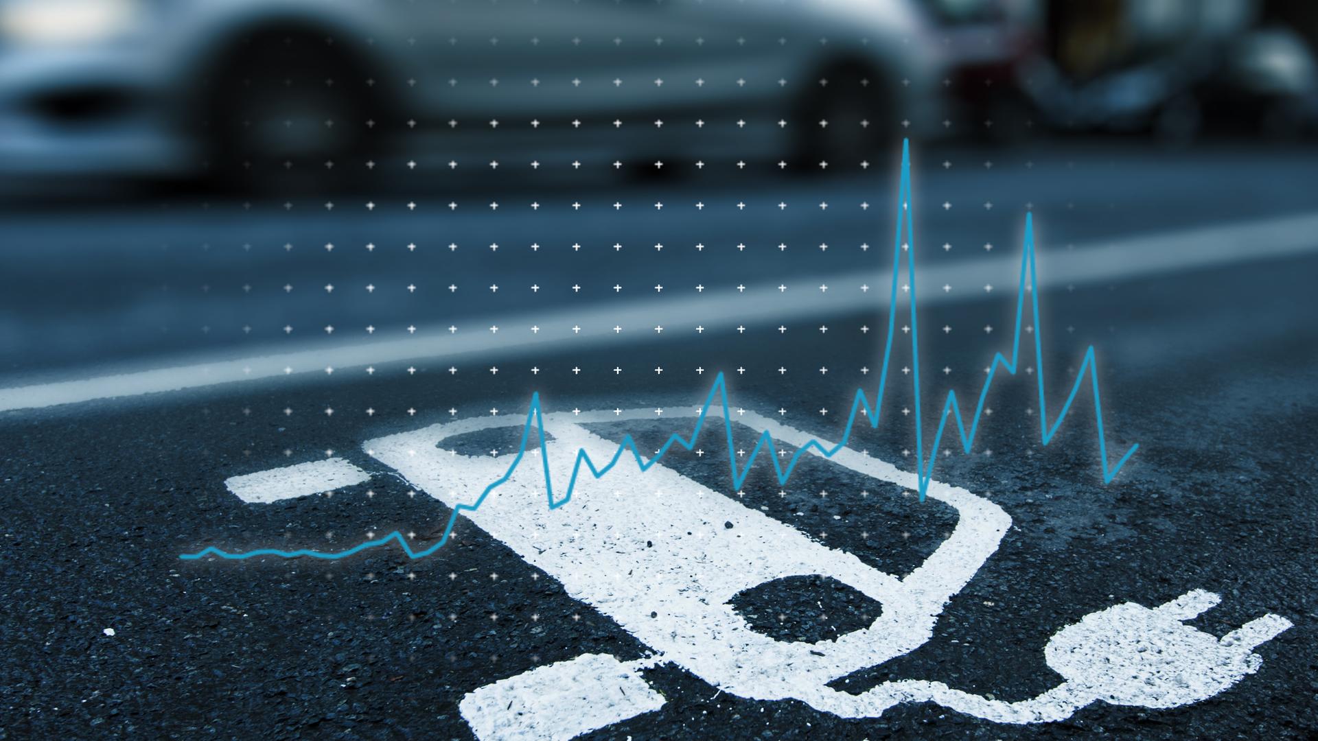 Über einem Parkplatz für E-Autos ist eine Liniengrafik eingeblendet, die zeigt, wie die Verkaufszahlen für E-Autos zuletzt gesunken sind.