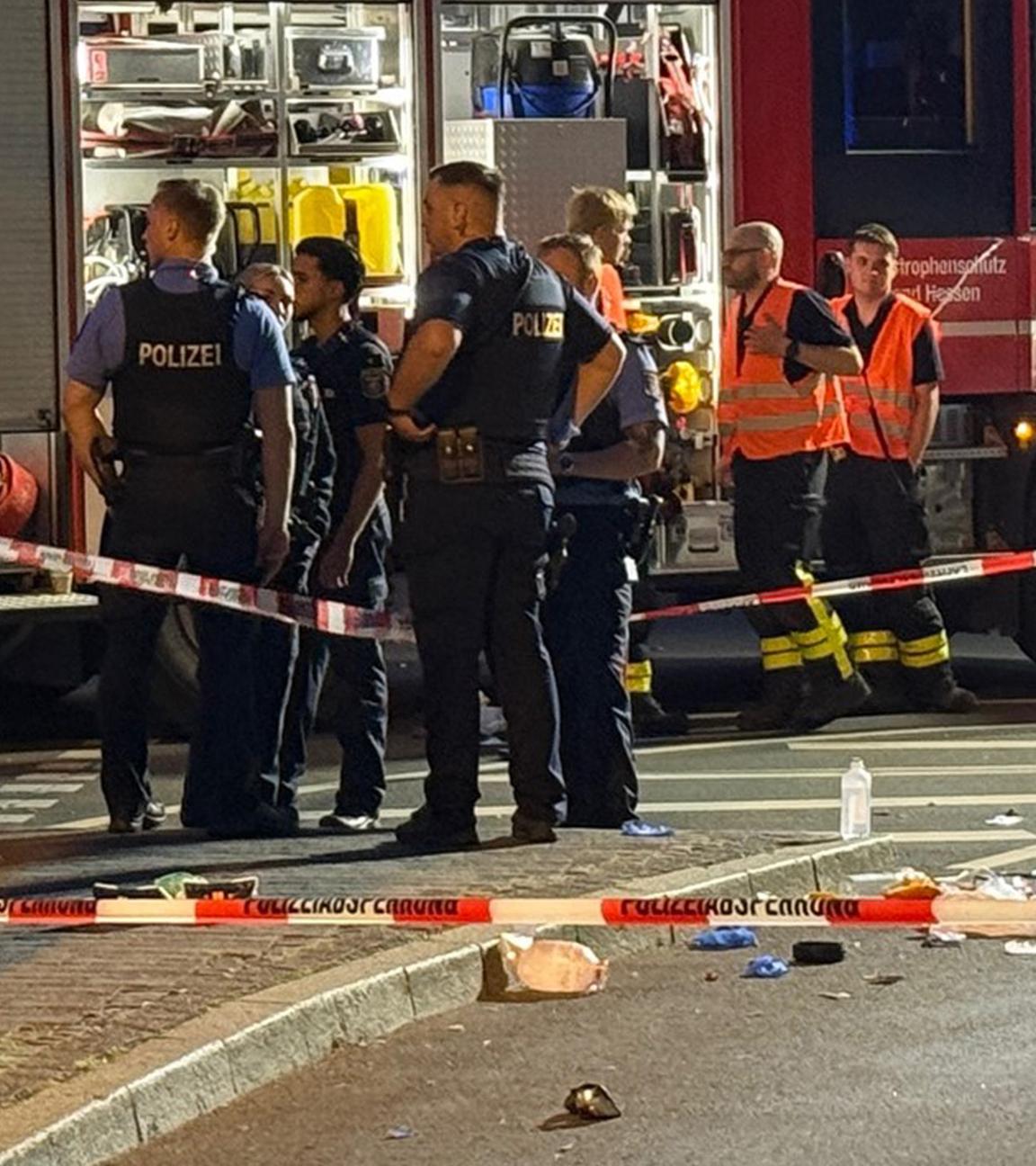  Einsatzkräfte der Polizei und Feuerwehr stehen am Unfallort an dem ein Autofahrer in der Nacht vom 06.07.2025 eine Person auf einem E-Scooter erfasst.