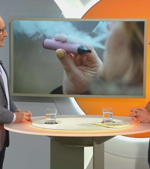 Dr. Christoph Specht bei Volle Kanne. Im Hintergrund ist ein Bild einer E-Zigarette.