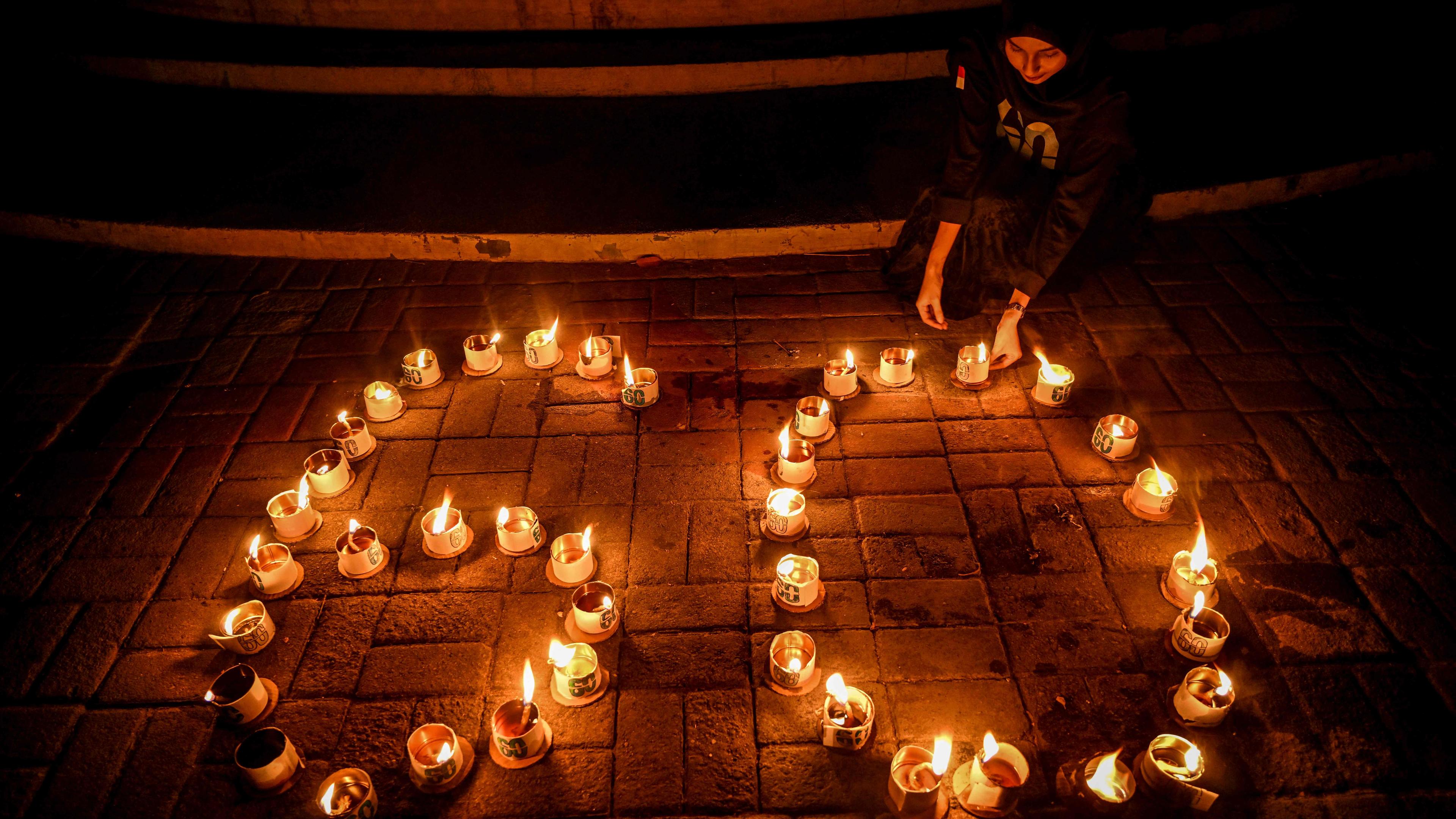 Eine Aktivistin zündet Kerzen zur "Earth Hour" in Indonesien an.