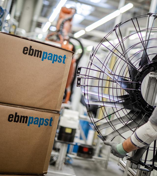 Ein Mitarbeiter des Elektromotoren- und Ventilatorenherstellers EBM-Papst, arbeitet in der Produktion an einem Ventilator.