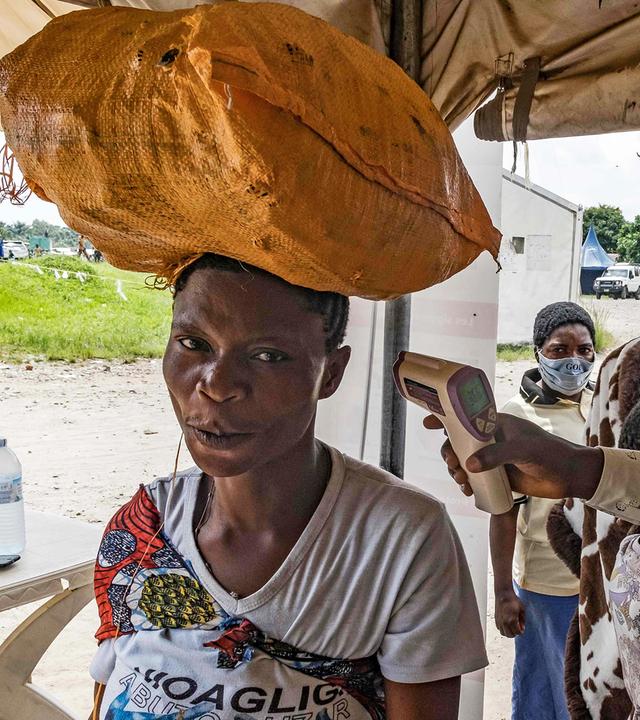Ein Gesundheitsbeamter in Uganda misst die Körpertemperatur eines Reisenden mithilfe eines kontaktlosen Infrarotthermometers, aufgenommen am 18.05.2026