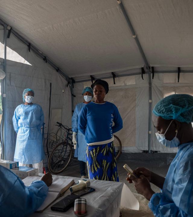 Eine Reisende wartet darauf, dass ihr von Gesundheitspersonal die Temperatur gemessen wird, nachdem sie am Anlegeplatz M’Poko Bac im Bezirk Bimbo südwestlich von Bangui angekommen ist.