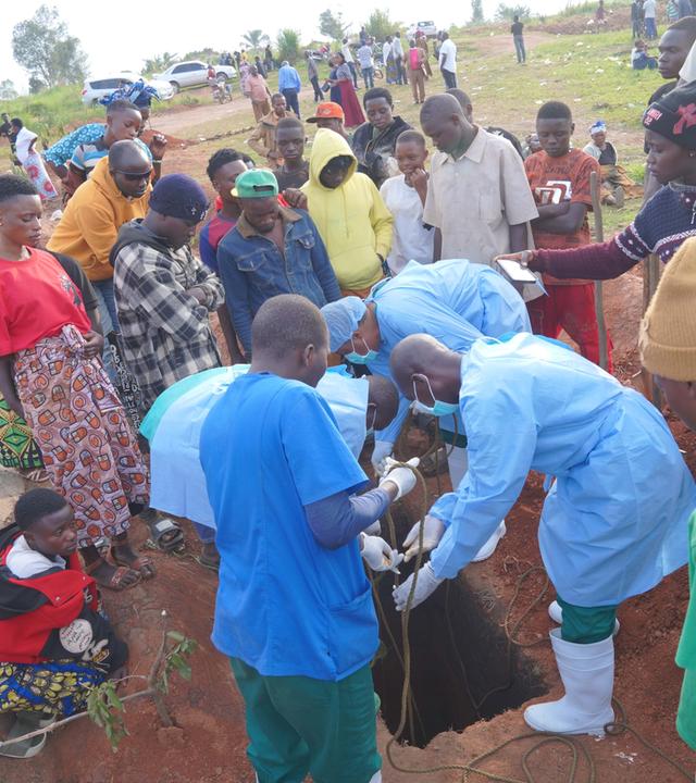  Mitglieder des Einsatzteams senken den Leichnam von Baudo Baraka Jules gemäß den Bestattungsvorschriften für Ebola-Opfer in Anwesenheit seiner Familie in Bunia, Demokratische Republik Kongo, am 18. August 2026 in ein Grab. 