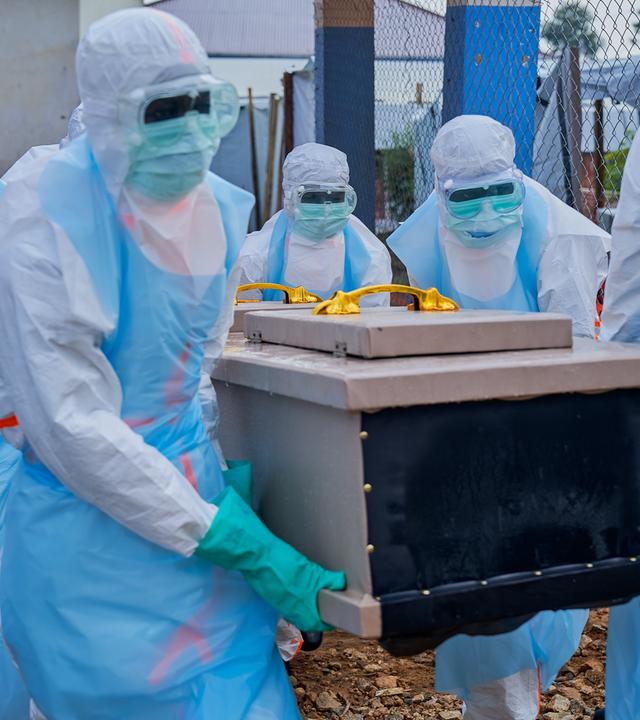 Mitarbeiter heben im Ebola-Behandlungszentrum des Allgemeinen Krankenhauses in Bunia in der Provinz Ituri in der Demokratischen Republik Kongo einen Sarg in ein Fahrzeug