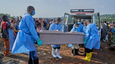 epa13127239 Staff prepare to bury the coffin of an Ebola victim in Bunia, Ituri province, Democratic Republic of Congo, 22 July 2026. According to the World Health Organization (WHO), the province of Ituri remains the epicenter of the Bundibugyo variant of the Ebola virus, reaching almost 1000 deaths. EPA/DIEUDONNE DIROLE