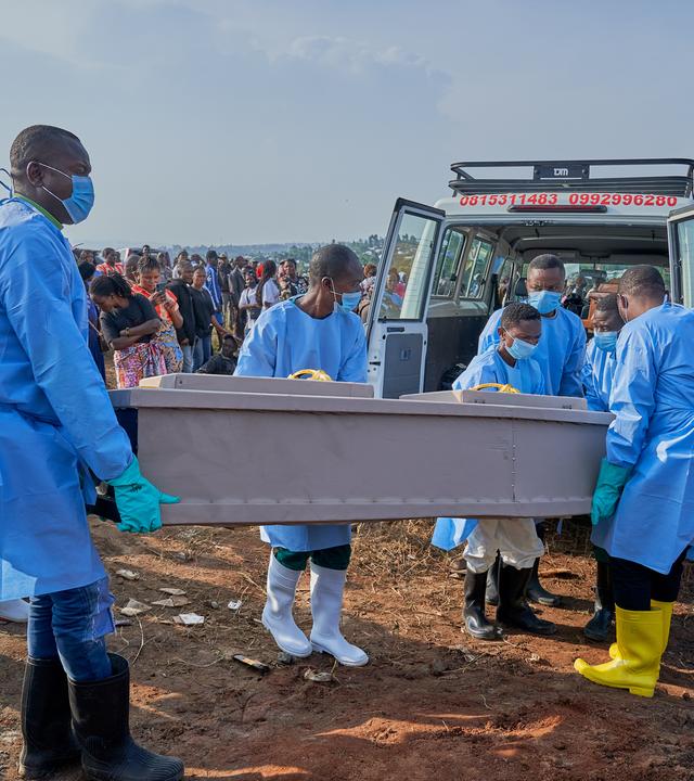 epa13127239 Staff prepare to bury the coffin of an Ebola victim in Bunia, Ituri province, Democratic Republic of Congo, 22 July 2026. According to the World Health Organization (WHO), the province of Ituri remains the epicenter of the Bundibugyo variant of the Ebola virus, reaching almost 1000 deaths. EPA/DIEUDONNE DIROLE