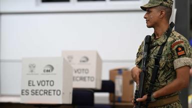 Wahlkabine zur Präsidentschaftswahl in Ecuador wird von bewaffneten Soldaten bewacht.