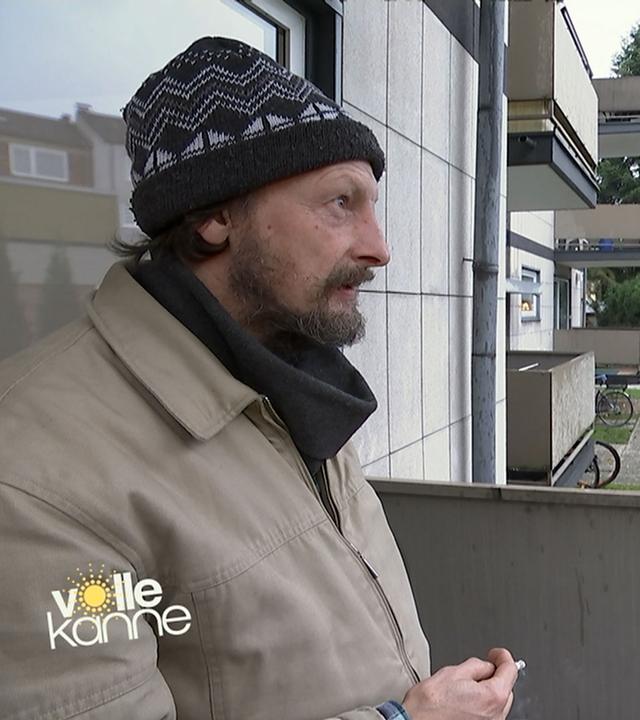 Ehemaliger Obdachloser Rolli auf dem Balkon seiner neuen Wohnung