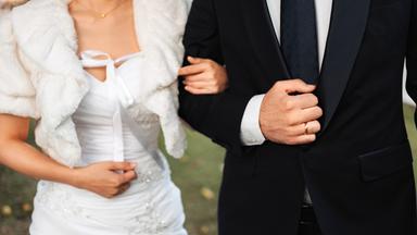 Ein Hochzeitspaar, das an seinem großen Tag gemeinsam spazieren geht