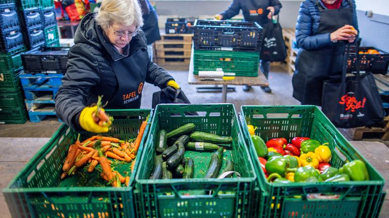 Ehrenamtliche Helfer sortieren Lebensmittel bei der Schweriner Tafel. 