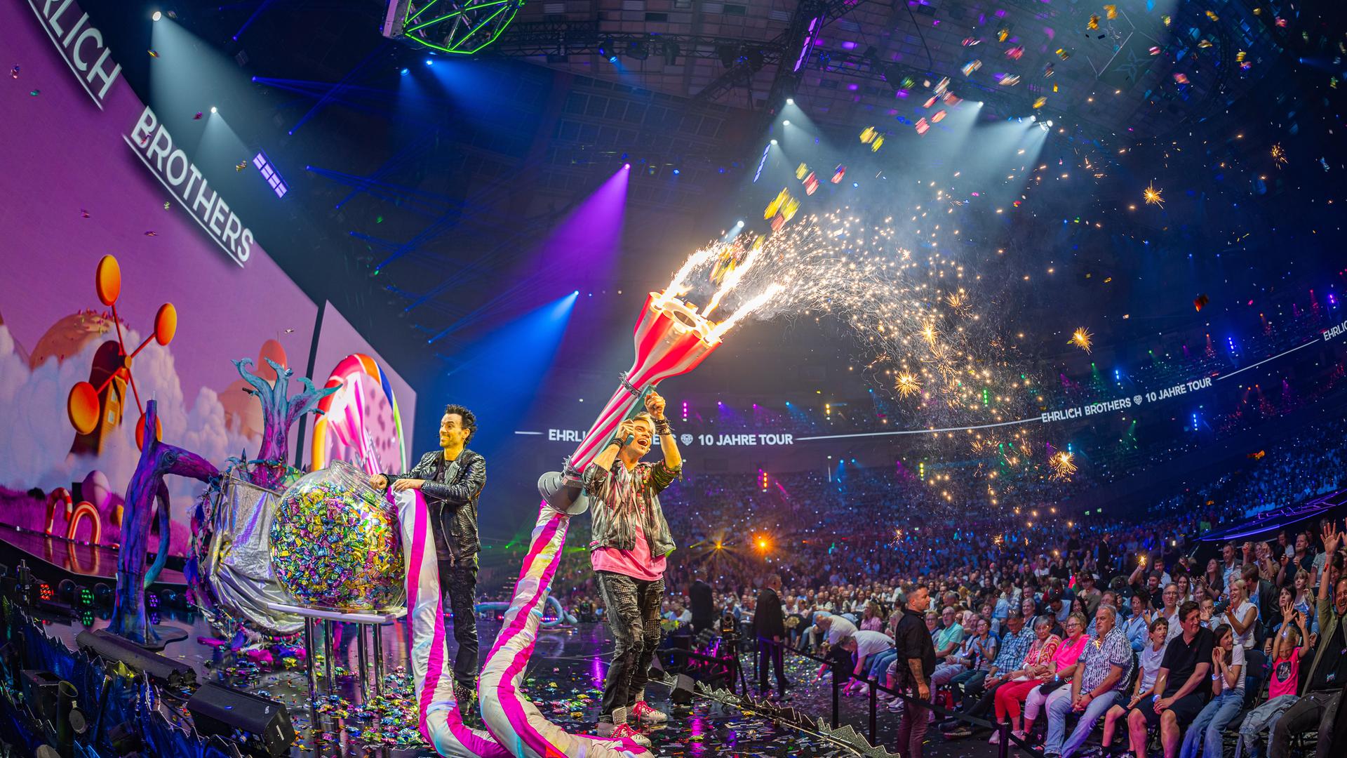 Andreas und Chris Ehrlich schießen mit einer riesigen Süßigkeiten-Kanone Bonbons in den Zuschauerraum.