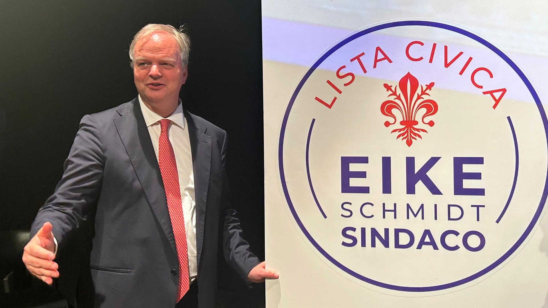 Eike Schmidt, Kunsthistoriker aus Deutschland, ehemaliger Museumsdirektor der Uffizien (2015-2023) und Mitte-Rechts-Kandidat um das Amt des Bürgermeisters in Florenz, gestikuliert neben einem Wahlplakat mit der Aufschrift: "Lista Civica Eike Schmidt Sindaco".