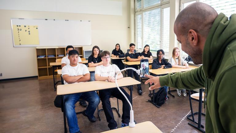 "37° - Ein Lehrer geht viral": Lehrer Reff steht vor der Klasse. Die Schüler sitzen an ihren Schultischen hören ihm zu.