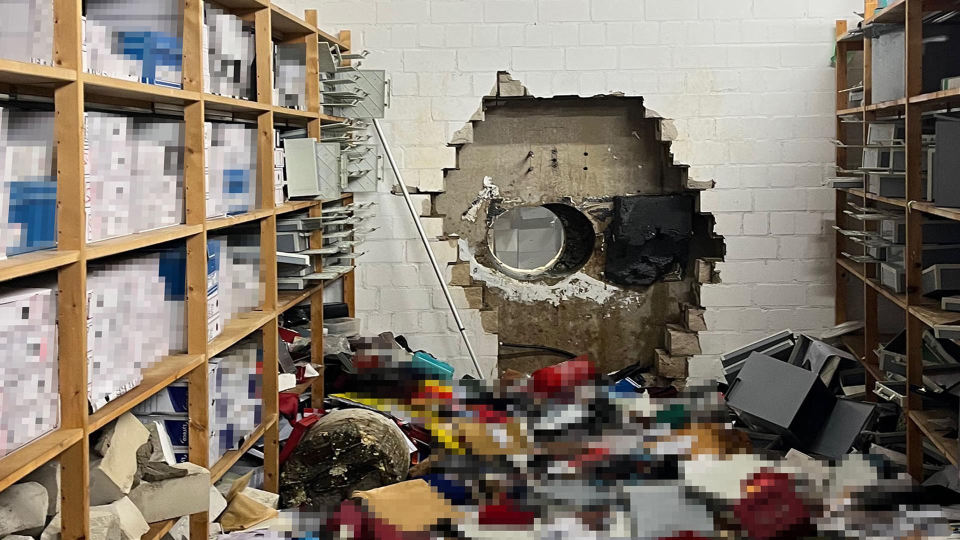 Ein großes Loch ist in der Wand des Tresorraums einer Sparkasse zu sehen.