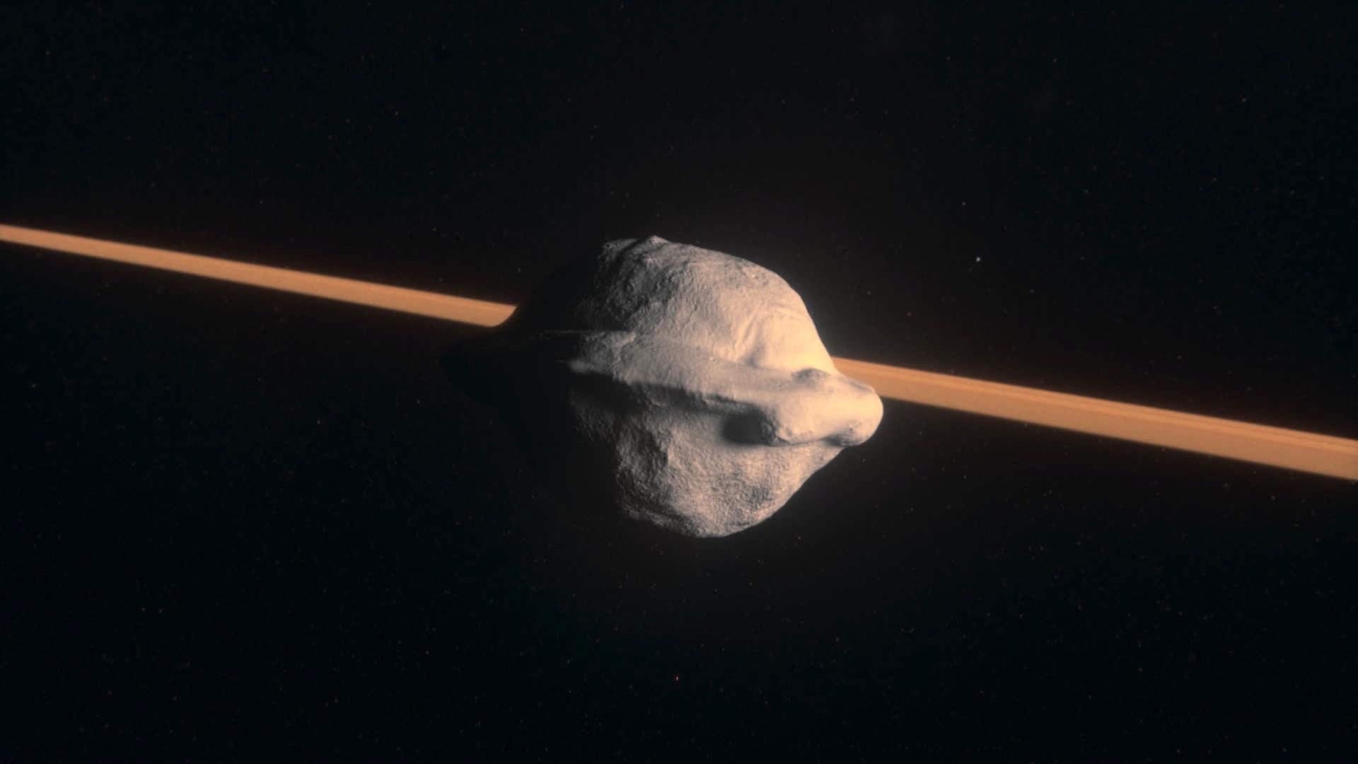Computeranimiertes Bild eines Himmelskörpers in Form einer Walnuss, der im All schwebt, im Hintergrund ein heller orangefarbener Streifen.