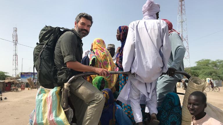 Reporter Reza Pakravan auf der Ladefläche eines Pick-up-Transporters, die er sich mit vielen Einheimischen teilt.