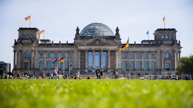 Vor und auf dem Reichstag wehen Deutschland-Fahnen. 