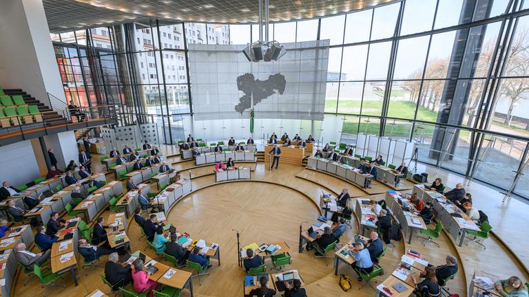 Im Sitzungs-Saal im Landtag vom Bundes-Land Sachen sitzen die Politiker.
