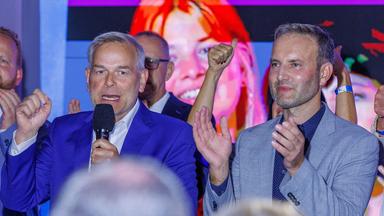Die AfD-Spitzenkandidaten Leif-Erik Holm (links) und Enrico Schult stehen nebeneinander. Holm spricht in ein Mikrofon, Schult klatscht dazu.