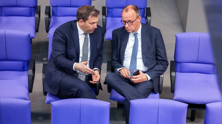 Bundestag - Sondersitzung zur Grundgesetzänderung -Merz und Klingbeil unterhalten sich