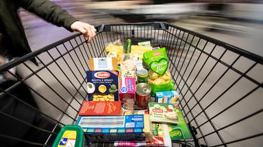 Einkaufswagen mit unterschiedlichen Lebensmitteln in Verpackungen