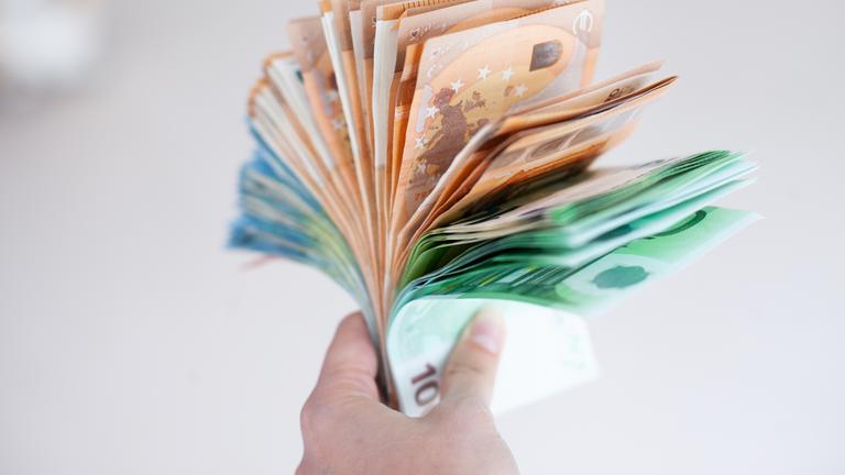 Hand hält ein Bündel Euro-Banknoten