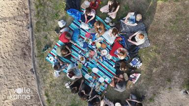 Eine Gruppe junger Menschen auf einer Picknick-Decke aus der Vogelperspektive