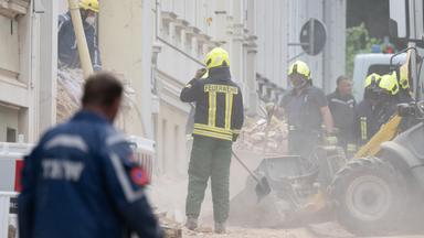 Einsatzkräfte der Feuerwehr und des Technischen Hilfswerks arbeiten sich am 21.05.2026 durch Trümmerteile eines eingestürzten Hauses in Görlitz.