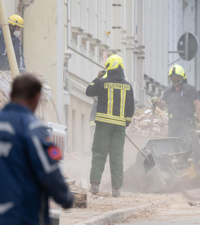 Einsatzkräfte der Feuerwehr und des Technischen Hilfswerks arbeiten sich am 21.05.2026 durch Trümmerteile eines eingestürzten Hauses in Görlitz.