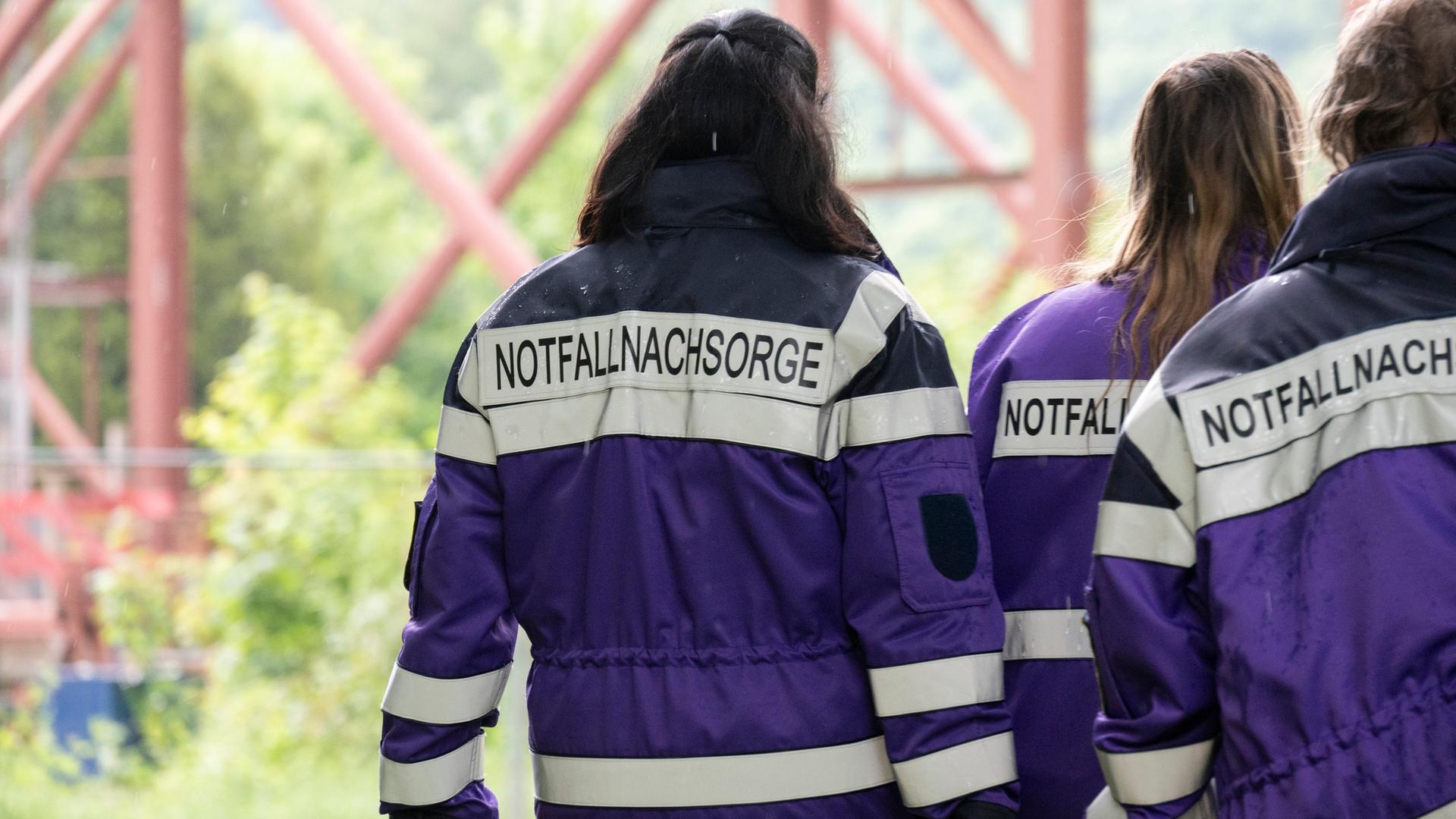 Drei Einsatzkräfte von der Notfallnachsorge stehen an der Unglücksstelle in Horb. An der Baustelle war eine Gondel mit drei Bauarbeitern in die Tiefe gestürzt.