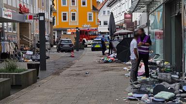 Einsatzkräfte stehen in der Stadt nachdem am 21.08.2026 im hessischen Hofgeismar ein Auto gegen die Hauswand eines Kaufhauses gefahren ist.