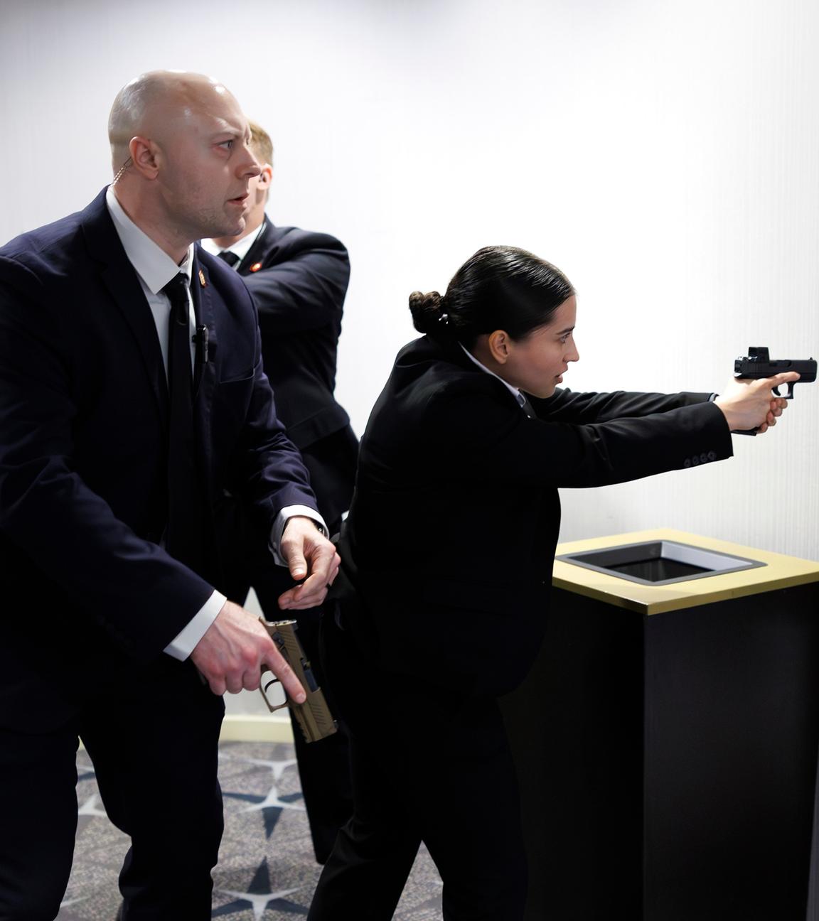 Einsatzkräfte der Strafverfolgungsbehörden mit Pistolen sichern das Gebäude