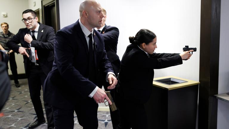 Einsatzkräfte der Strafverfolgungsbehörden mit Pistolen sichern das Gebäude