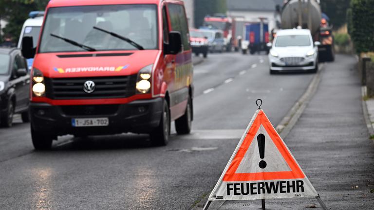 Ein belgisches Feuerwehrauto fährt am 17.08.2026 an der Einsatzleitung in Kalterherberg, Monschau, vorbei.