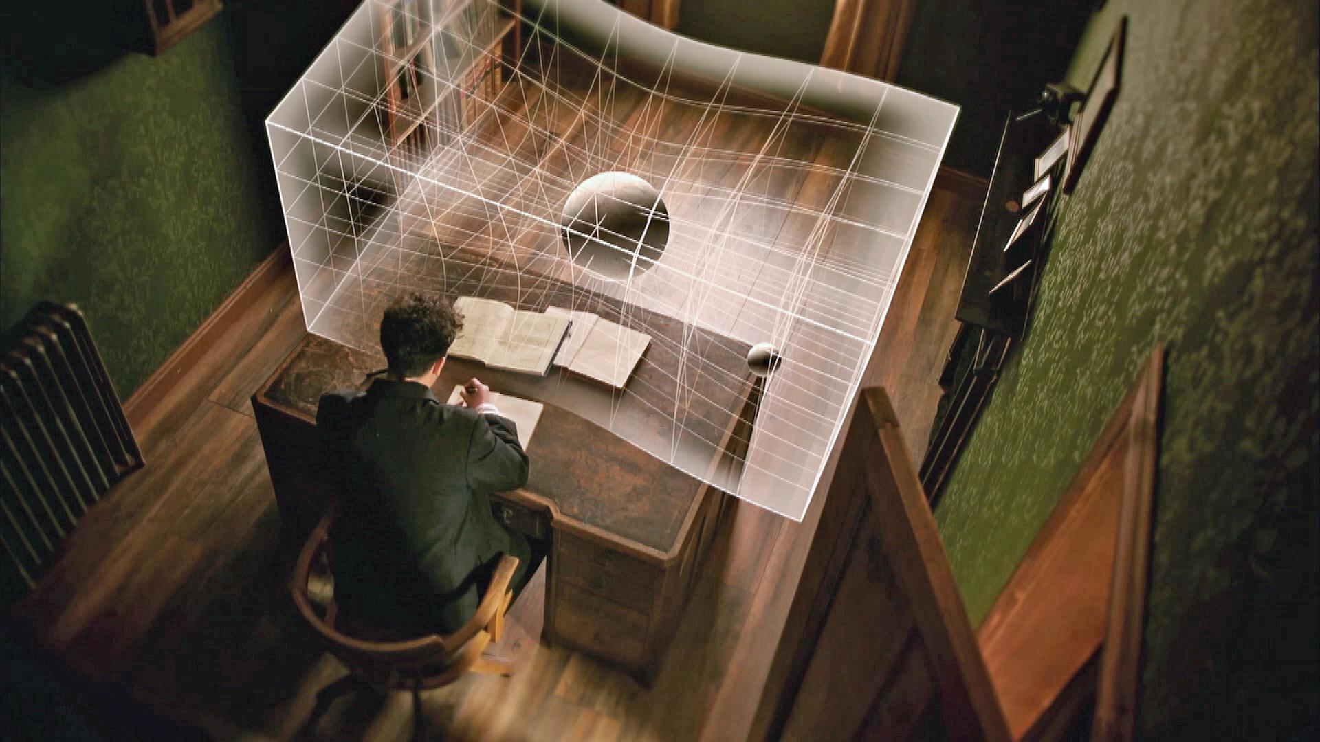 Einstein am Schreibtisch mit Modell der gekrümmten Raumzeit (Spielszene mit Grafik)